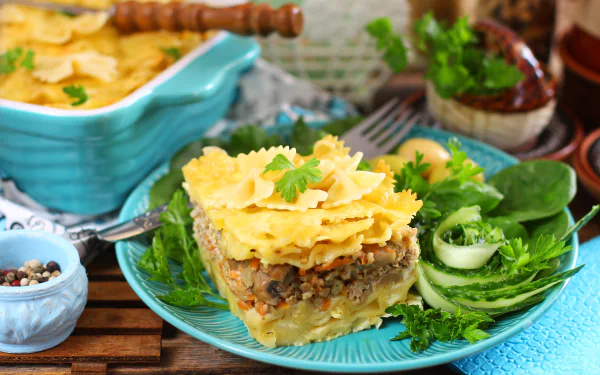 5K Ultra HD PC desktop wallpaper of food: plated pasta stuffing casserole — layered pasta sheets with savory stuffing and herbs, served with fresh greens on a turquoise plate.