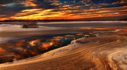 Florida sunset over sandy tidal flats, fiery clouds mirrored in calm reflection pools — vibrant nature scene, 2K Quad HD PC desktop wallpaper/background.