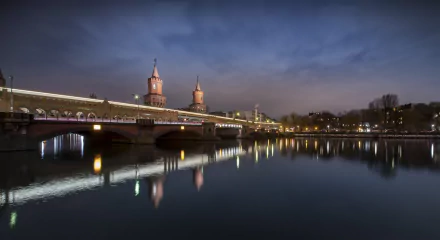 Oberbaum Bridge illuminated at evening over the Spree River in Berlin, Germany, captured in stunning 4K Ultra HD.