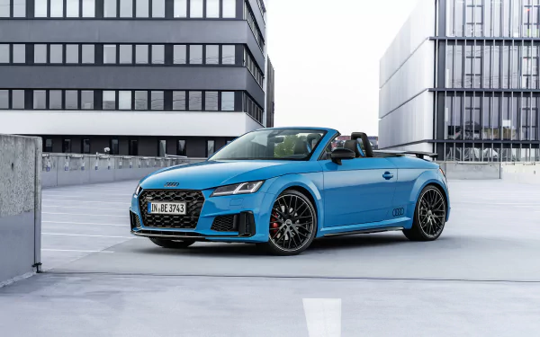Blue Audi TTS Competition Plus cabriolet (Audi TT) parked on a rooftop between modern office buildings — 4K Ultra HD PC desktop wallpaper.