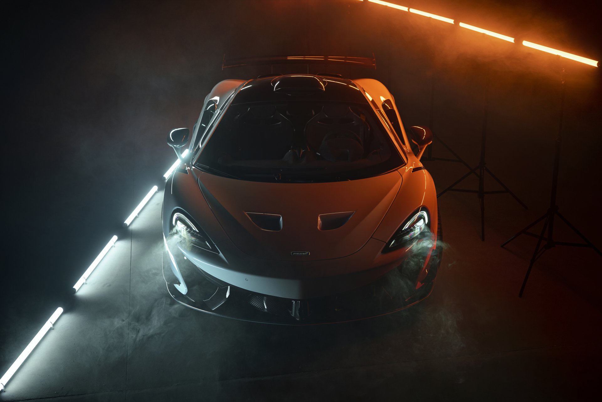 Orange McLaren 620R supercar showcased in dramatic lighting with fog, captured in stunning 8K Ultra HD as a PC desktop wallpaper and background.