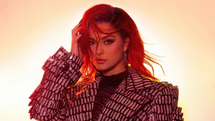 Backlit portrait of a red-haired singer in a patterned blazer and bold makeup, glowing golden rim light — 4K Ultra HD music-themed PC desktop wallpaper.