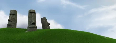 HD desktop wallpaper featuring two man-made moai statues with distinct faces against a clear sky and green grassy hill.