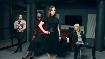 HD desktop wallpaper featuring four characters from Flack posed confidently in a stylish, dark office setting.