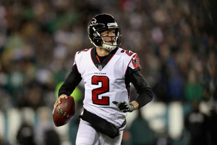 HD wallpaper featuring Matt Ryan, wearing his Atlanta Falcons uniform, in action on the football field, showcasing his dynamic athleticism and determination.