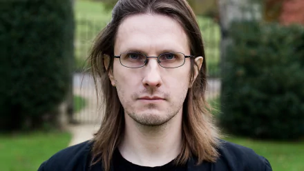 HD desktop wallpaper featuring a man with shoulder-length hair and glasses, tagged as Steven Wilson, with a subdued outdoor backdrop.