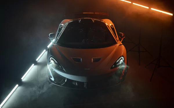 Orange McLaren 620R supercar showcased in dramatic lighting with fog, captured in stunning 8K Ultra HD as a PC desktop wallpaper and background.