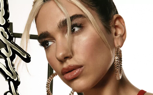 Close-up 4K Ultra HD PC desktop wallpaper: a singer's face with glossy makeup and face‑framing blonde strands, wearing large chain hoop earrings, studio-lit against a pale backdrop.