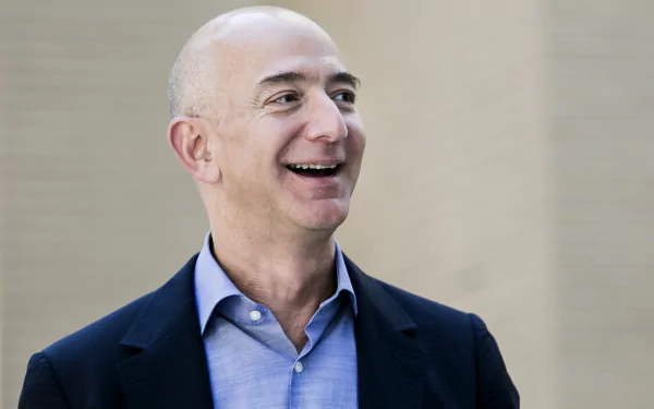 HD desktop wallpaper featuring a smiling man in a suit, set against a subdued background.