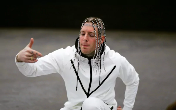 HD desktop wallpaper featuring a person in white clothing reaching out, with braided hair and an intense expression.