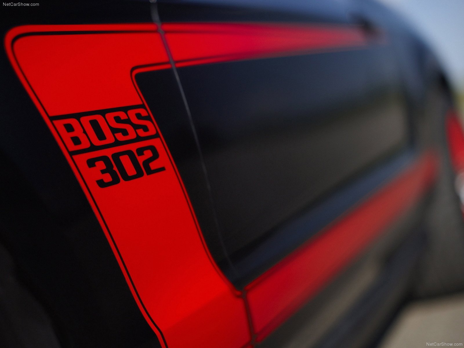 Close-up of a Ford Mustang Boss 302, showcasing its striking black and red design. This HD image serves as a dynamic desktop wallpaper for auto enthusiasts.