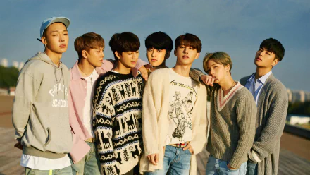 HD desktop wallpaper featuring the members of iKON posing together against a clear sky backdrop.