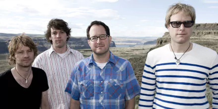 HD desktop wallpaper featuring the members of The Hold Steady with a scenic backdrop.