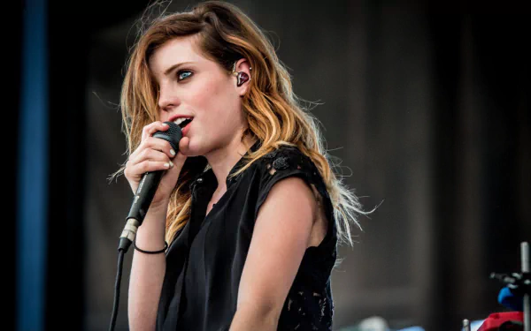 HD desktop wallpaper of Echosmith's Sydney Sierota performing on stage with a microphone.