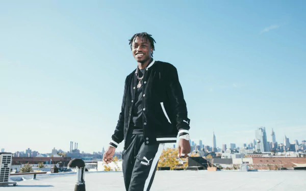 A smiling person in stylish attire stands on a rooftop with a city skyline in the background, HD desktop wallpaper.
