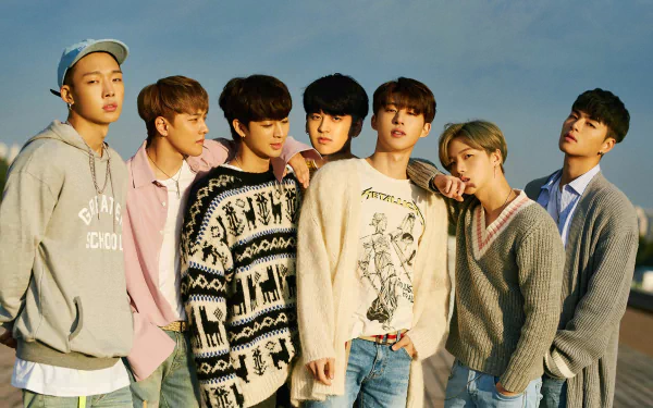 HD desktop wallpaper featuring the members of iKON posing together against a clear sky backdrop.