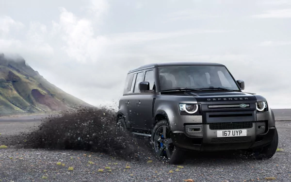 A black Land Rover Defender SUV kicks up dirt on a rugged terrain under a cloudy sky, captured in a sharp 4K Ultra HD desktop wallpaper image.