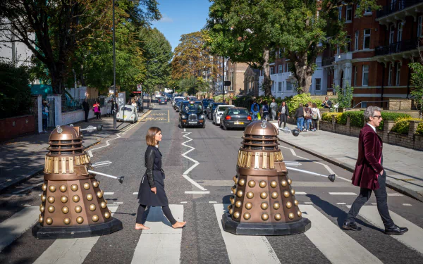 HD desktop wallpaper featuring two Daleks from the TV show Doctor Who crossing a busy street alongside pedestrians.