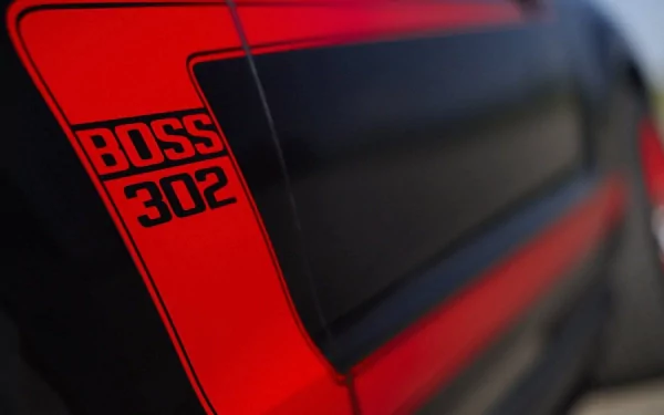 Close-up of a Ford Mustang Boss 302, showcasing its striking black and red design. This HD image serves as a dynamic desktop wallpaper for auto enthusiasts.