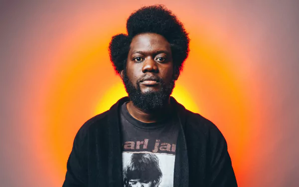 HD desktop wallpaper featuring a person with an orange backdrop.