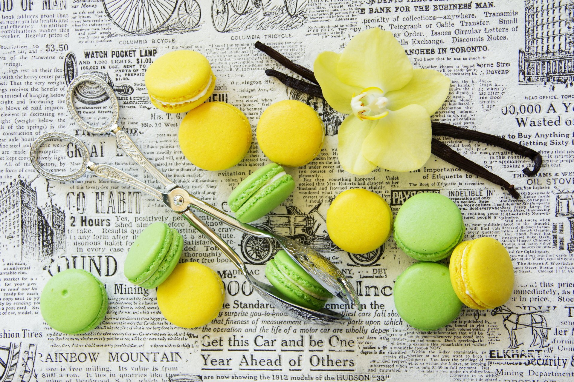 5K Ultra HD PC desktop wallpaper: green and yellow macarons arranged on vintage newspaper with orchid, vanilla beans and antique scissors — food, macaron background.
