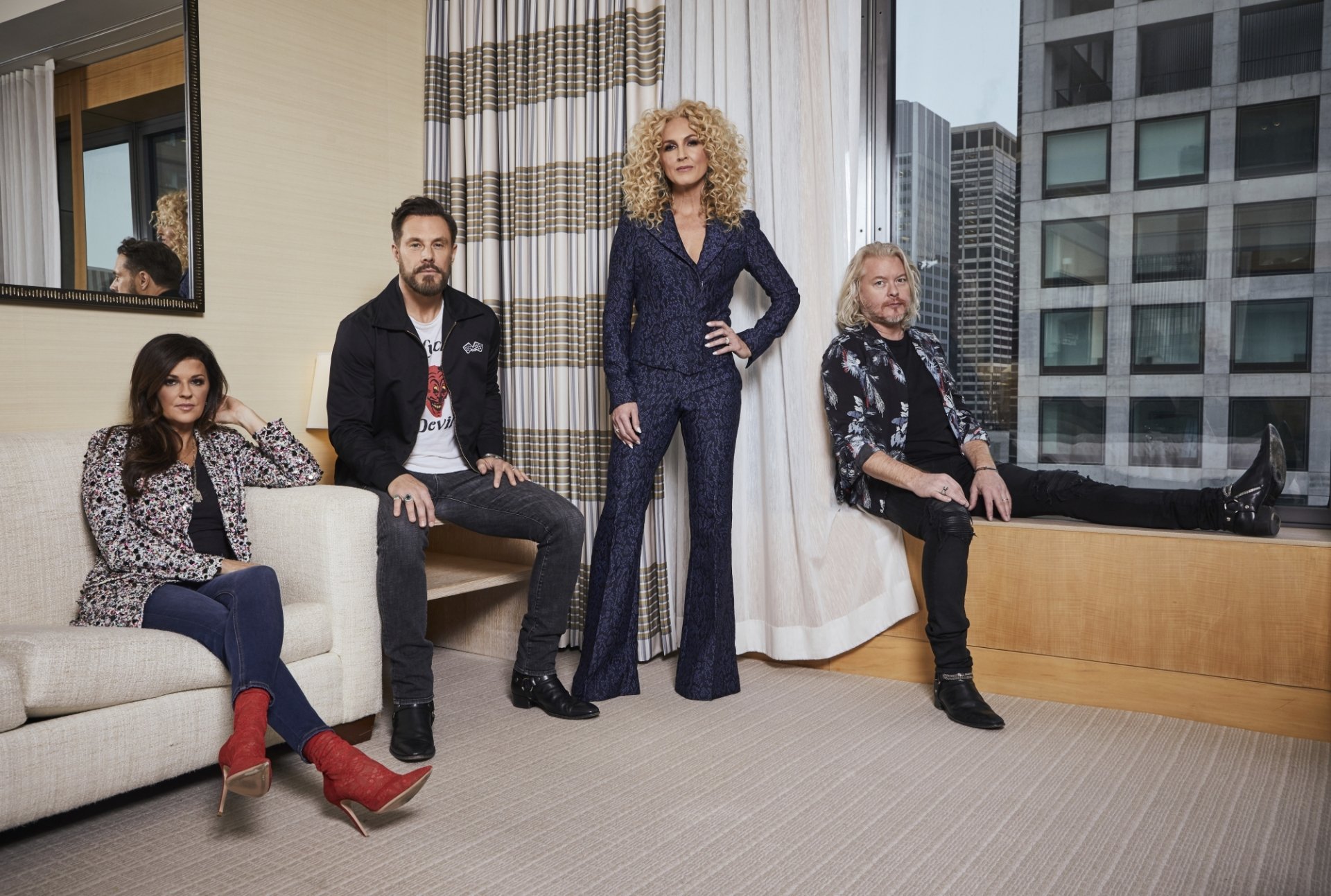 HD wallpaper of Little Big Town band members posing together in a modern room with cityscape background.
