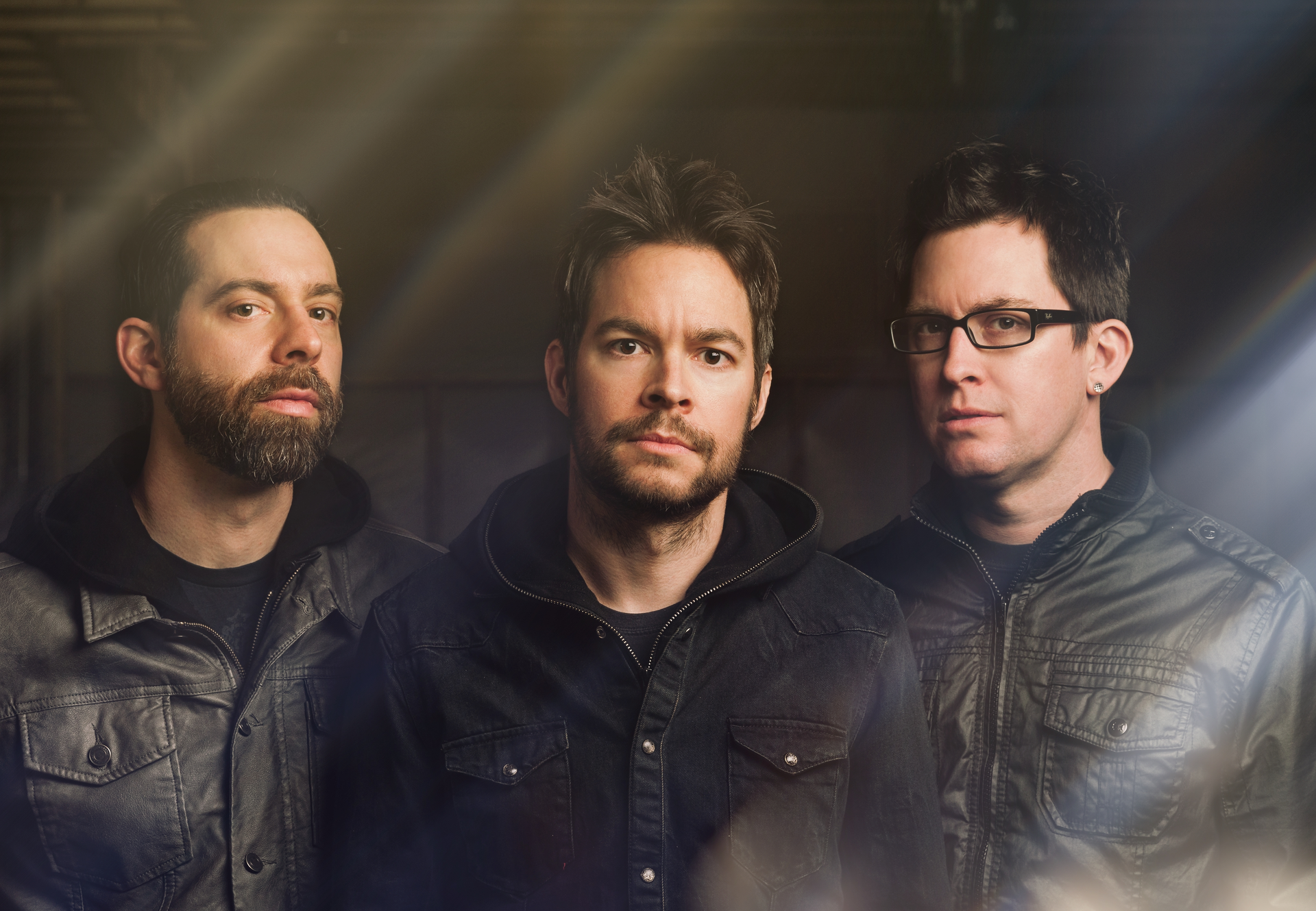 HD desktop wallpaper featuring three members of Chevelle with a dramatic backlight effect.