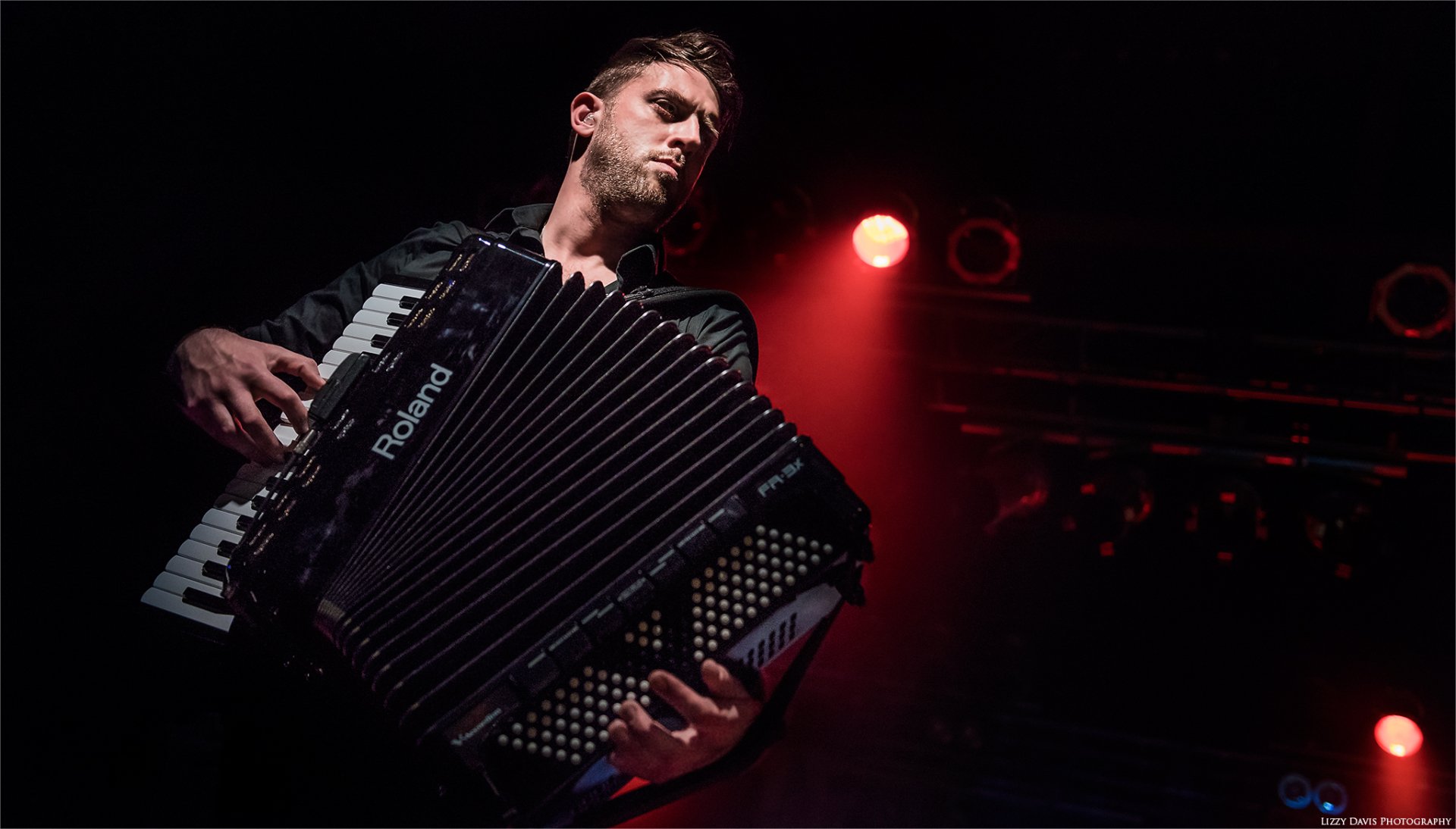 HD desktop wallpaper featuring a male accordion player onstage with red stage lighting, representing the Dropkick Murphys band.