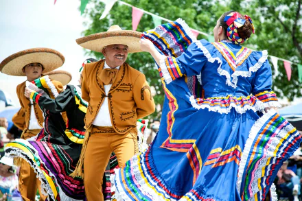 A vibrant scene of traditional Mexican dancing, featuring dancers in colorful attire and sombreros, captures the essence of cultural celebration. An eye-catching HD wallpaper for desktop backgrounds.