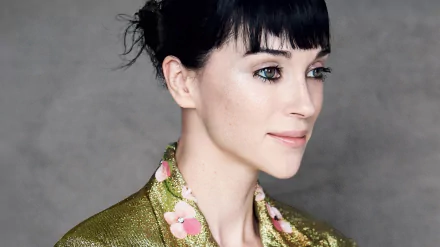 HD desktop wallpaper featuring a person with dark hair and a green floral outfit, tagged as St. Vincent, set against a neutral background.