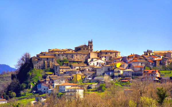 HD PC desktop wallpaper: man-made hilltop village in Campania, Italy — warm-toned houses clustered under a clear blue sky.