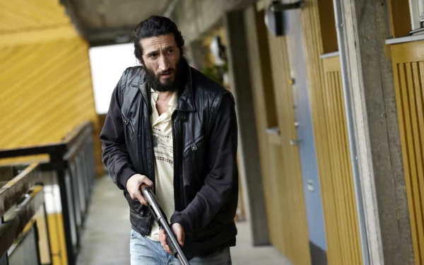 HD desktop wallpaper from Snabba Cash featuring a man with a gun in a tense hallway scene.