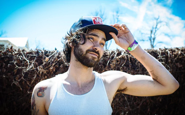 HD wallpaper featuring a person adjusting their cap with a natural backdrop, tagged as Shakey Graves.