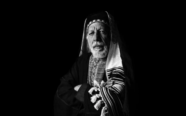 HD desktop wallpaper from 'The Chosen' featuring a black and white image of a man in traditional attire against a dark background.