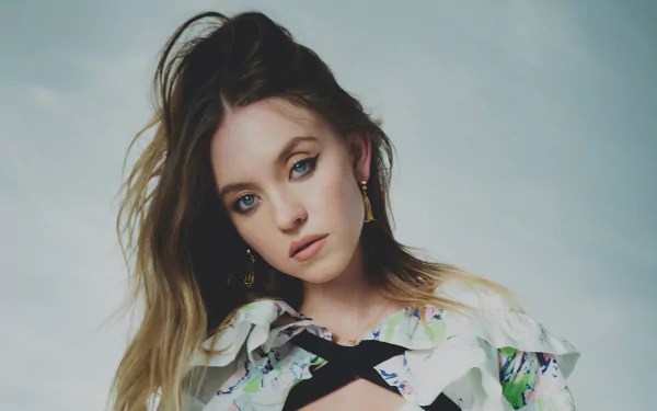 Brunette woman in a patterned blouse gazes toward the camera against a soft neutral backdrop — 4K Ultra HD PC desktop wallpaper.