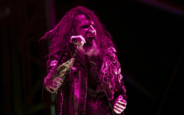 HD wallpaper of Rob Zombie performing on stage, clad in a detailed jacket, under purple stage lighting, suitable as a desktop background.