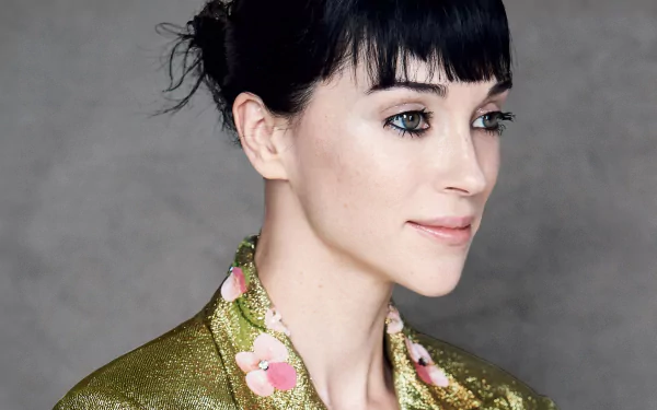 HD desktop wallpaper featuring a person with dark hair and a green floral outfit, tagged as St. Vincent, set against a neutral background.