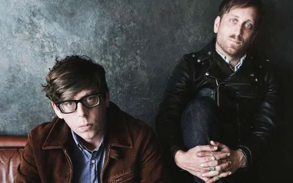 HD desktop wallpaper featuring two band members sitting against a textured backdrop, representing The Black Keys style.