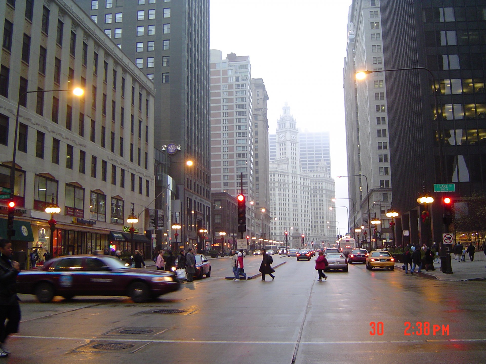 HD PC desktop wallpaper showcasing a bustling man-made Chicago street scene with traffic and pedestrians between tall city buildings at dusk.
