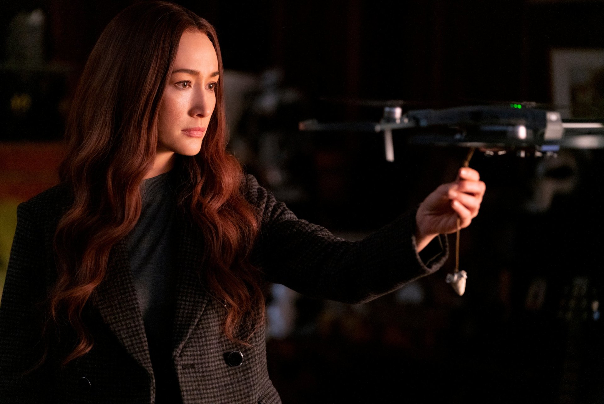 Maggie Q in a scene from the movie The Protégé, featured in an HD PC desktop wallpaper showing her holding a drone.