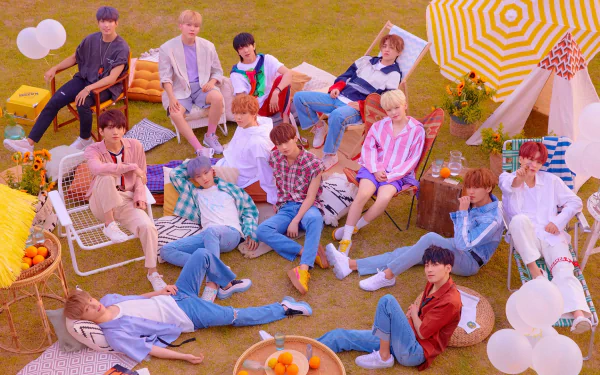 A vibrant HD desktop wallpaper featuring the K-pop group Seventeen relaxing outdoors amidst colorful decor and playful set pieces, embodying a cheerful and lively atmosphere.