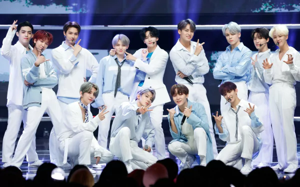 A vibrant HD wallpaper showcasing the K-pop group Seventeen, featuring the members in stylish outfits, posing energetically on stage with dynamic lighting.