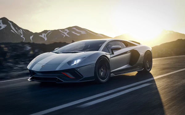 Silver Lamborghini Aventador LP 780-4 Ultimae supercar driving on a mountain road at sunrise — 4K Ultra HD PC desktop wallpaper/background.