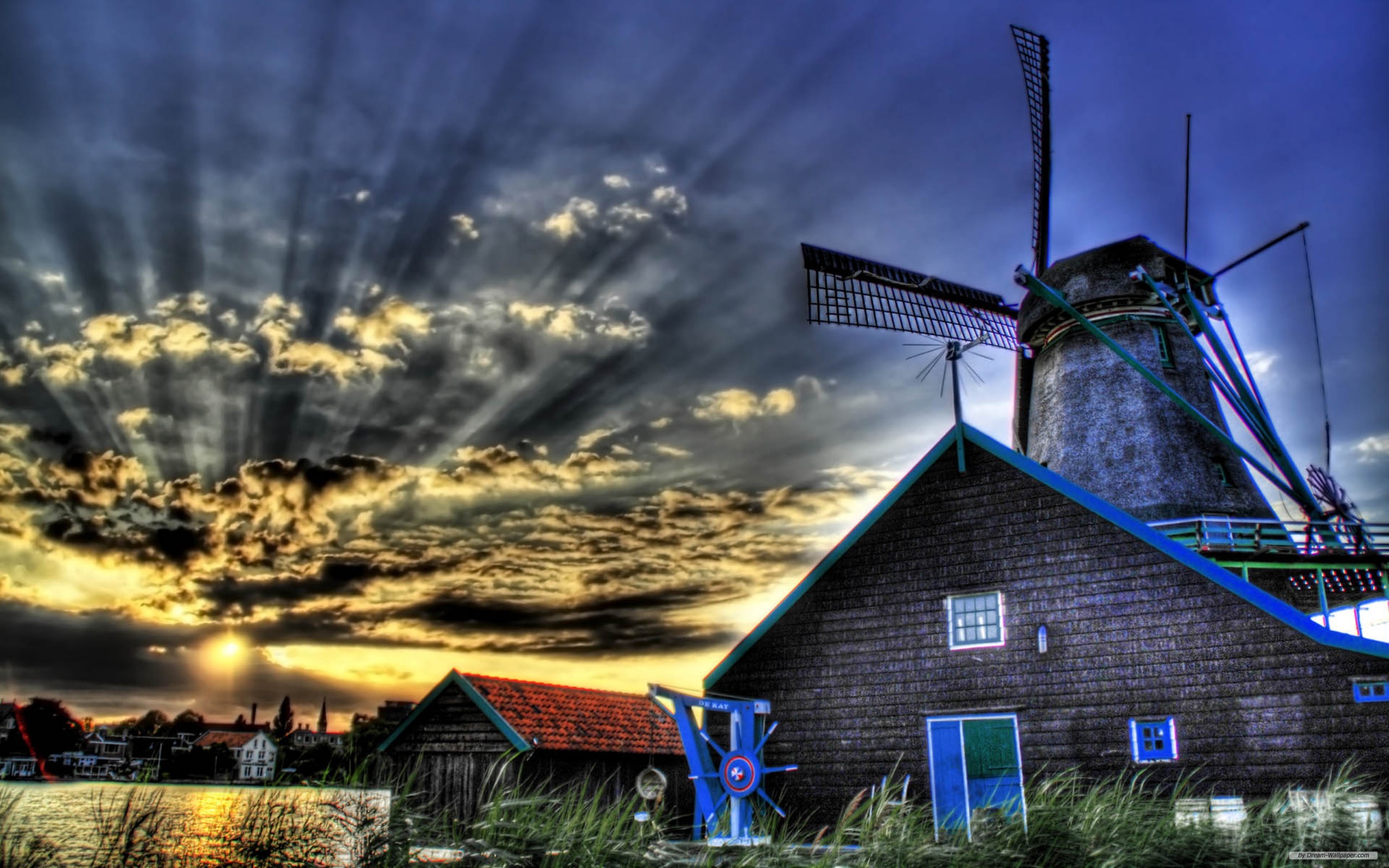 Surreal HDR photography of a windmill at sunset, with sunbeams shining through.