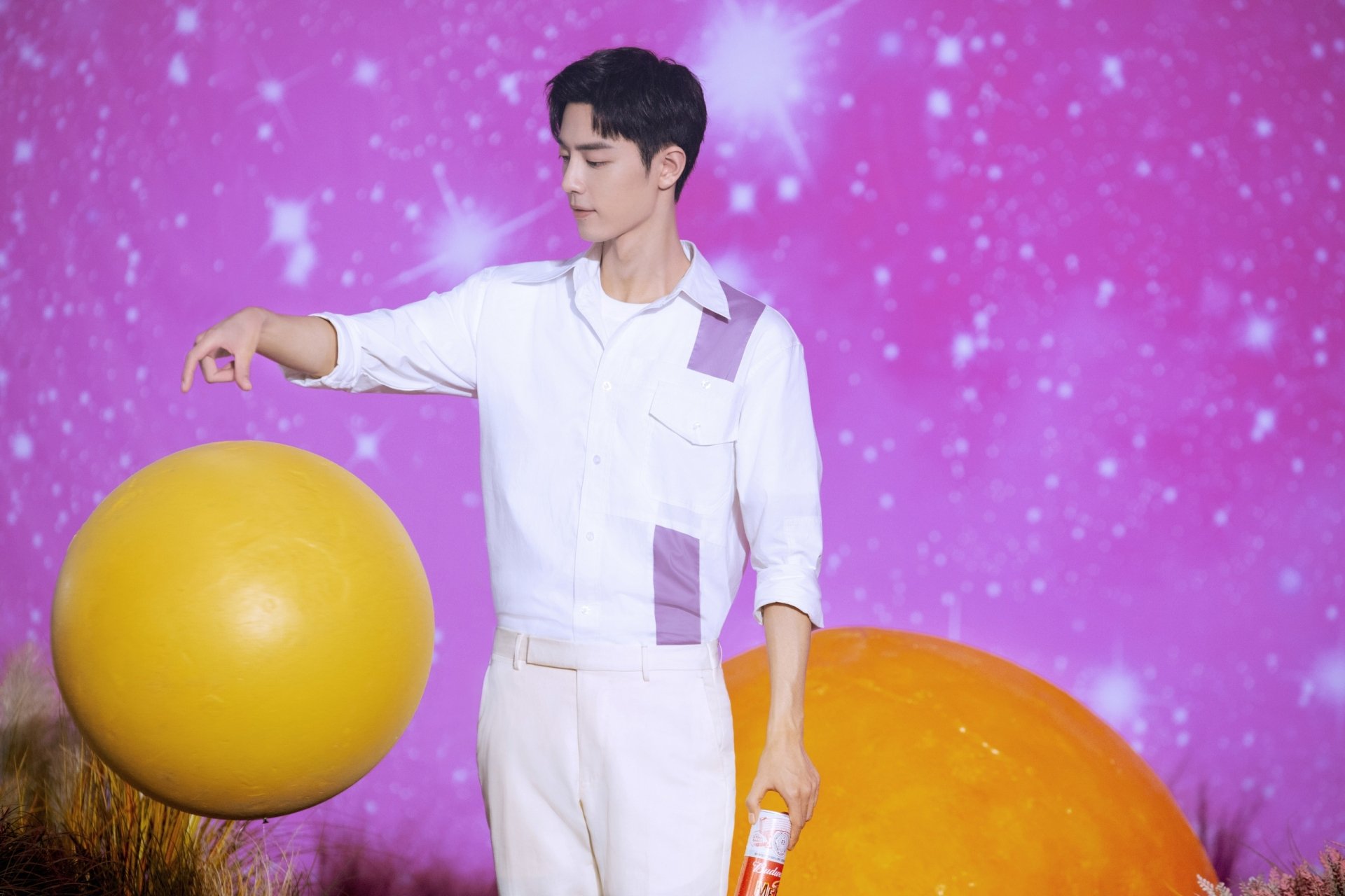2K Quad HD PC desktop wallpaper: young man in a white outfit touching a large yellow sphere, another sphere nearby, set against a pink, starry backdrop.