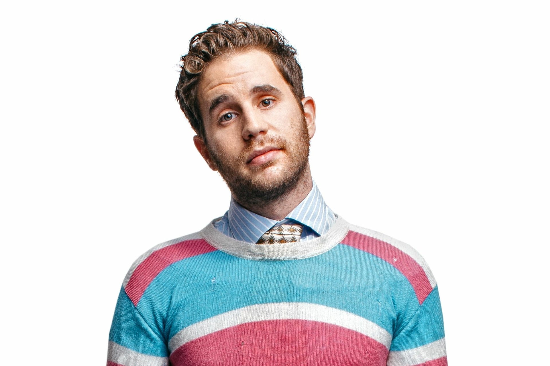 Stylish man in a colorful striped sweater posing for a HD desktop wallpaper and background image.