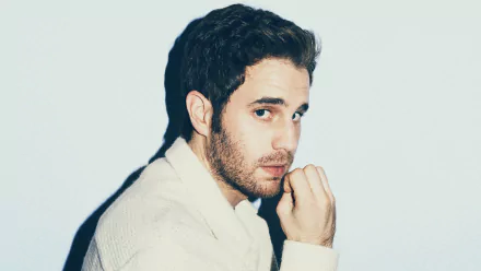 Man in a white sweater posing thoughtfully for a HD desktop wallpaper.