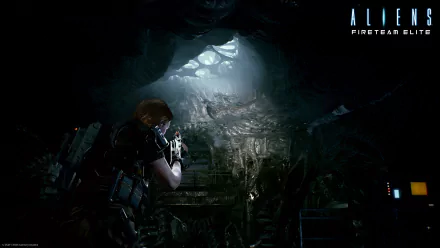 Aliens: Fireteam Elite HD Wallpaper featuring a marine exploring a dark, alien-infested cave environment.