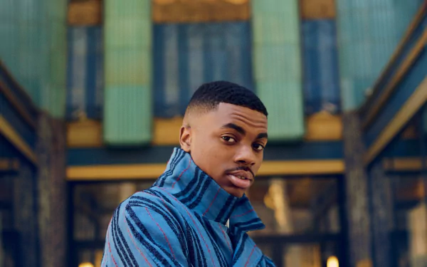 HD desktop wallpaper featuring a person in a blue striped shirt looking over shoulder with an architectural background.