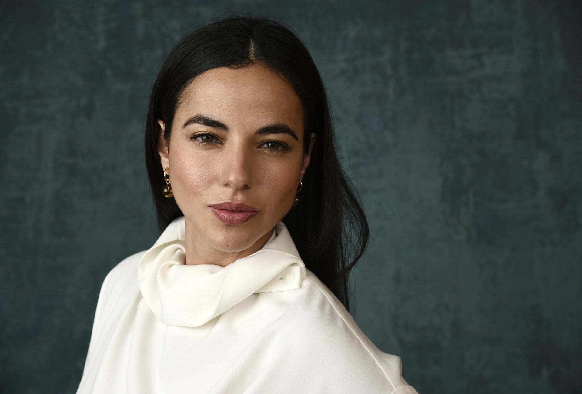 Elegant woman in a stylish white blouse posing against a textured dark background - HD desktop wallpaper and background.